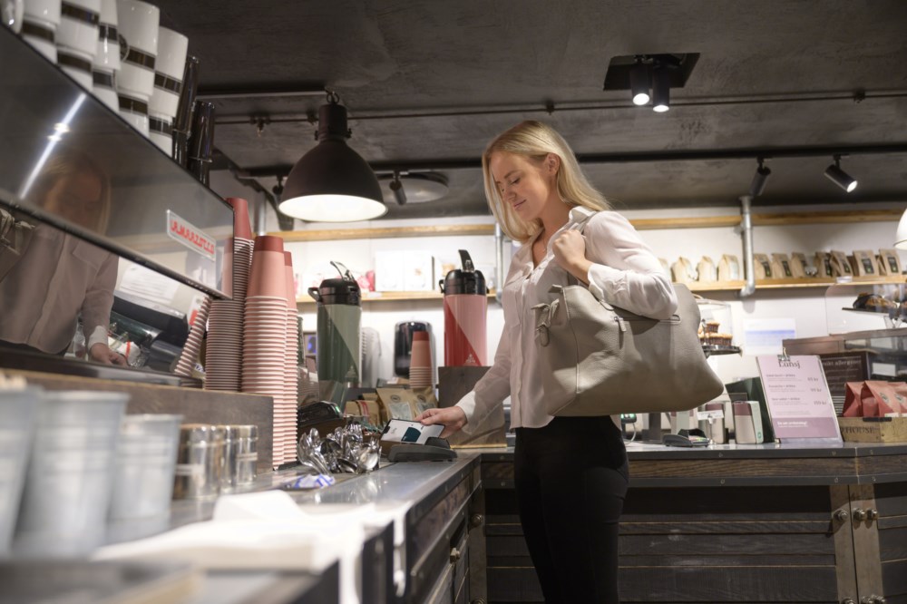 Dame som betaler med kort i en kantine